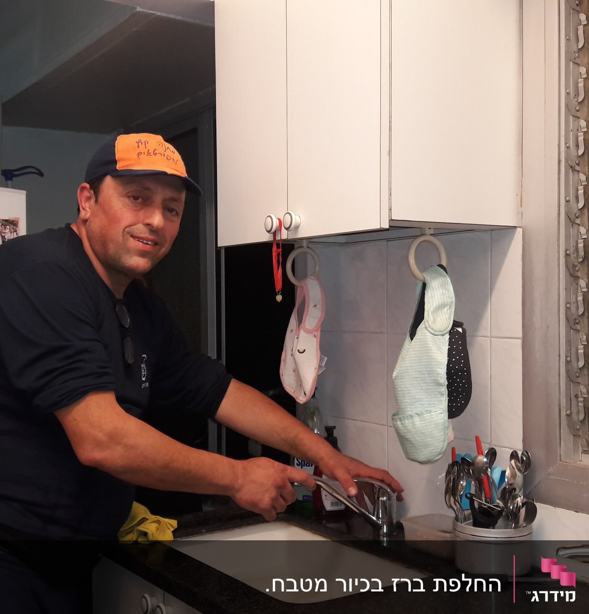 אדם מתקן ברז במטבח עם כלים